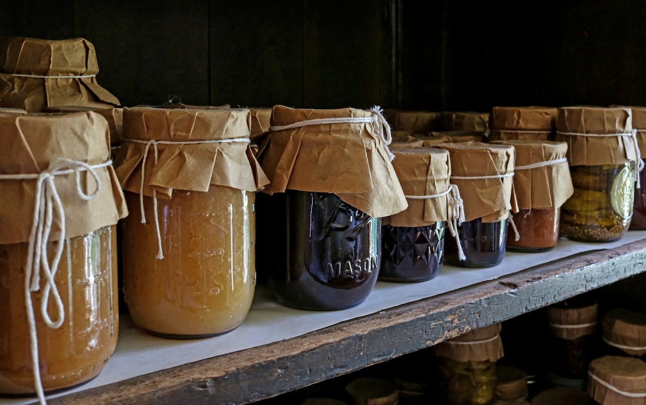 Canning jars full of preserved food on pantry shelves